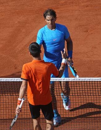 Novak Djokovic (L) of Serbia meets Rafael Nadal of Spain at the net after winning their French Open men s quarterfinal match at Roland Garros in Paris on June 3, 2015. Djokovic defeated Nadal 7-5, 6-3, 6-1 to advance to the next round.  PAR20150603731 DAVIDxSILPA