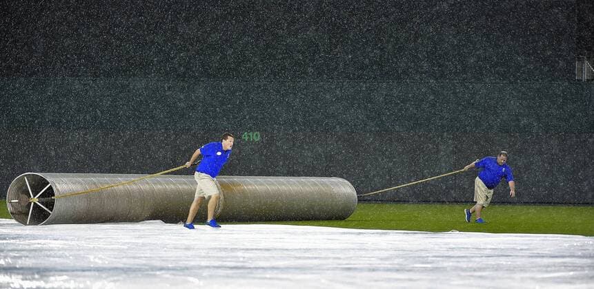 June 4, 2015 - Kansas City, MO, USA - Kansas City Royals tarp crew members roll back a cylinder in the rain that s used to roll up the tarp during an eighth-inning rain delay at Kauffman Stadium in Kansas City, Mo., on Thursday, June 4, 2015. Cleveland at Kansas City - ZUMAm67_