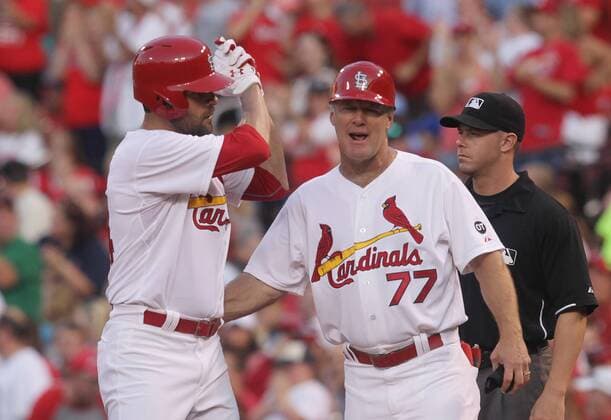 St. Cardinals starting pitcher Jaime Garcia motions to the dugout as first base coach Chris Maloney congratulates him on his RBI single in the second innng against the Kansas City Royals at Busch Stadium in St. Louis on June 12, 2015.  SLP2015061202 BILLxGREENBLATT