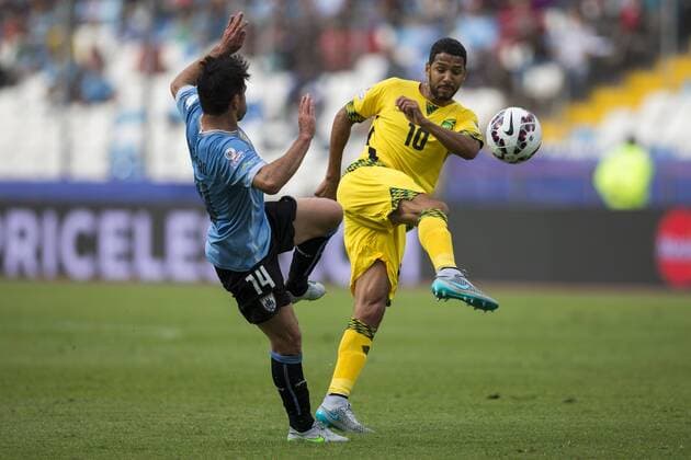 (150614) -- ANTOFAGASTA, June 14, 2015 -- Nicolas Lodeiro (L) of Uruguay vies with Jobi McAnuff of Jamaica during a Group B match at Copa America 2015, in Antofagasta, Chile, on June 13, 2015. Uruguay won 1-0. ) (SP)CHILE-ANTOFAGASTA-COPA AMERICA-GROUP B-URUGUAY VS JAMAICA LuisxEcheverria 