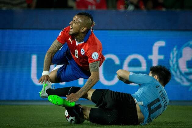 SANTIAGO, 2015 -- Arturo Vidal (Top) of Chile is tackled by Jorge Fucile of Uruguay during their quarterfinal at 2015 Copa America in Santiago, Chile, on June 24, 2015. ) (SP)CHILE-SANTIAGO-COPA AMERICA-CHILE VS URUGUAY PedroxMera 