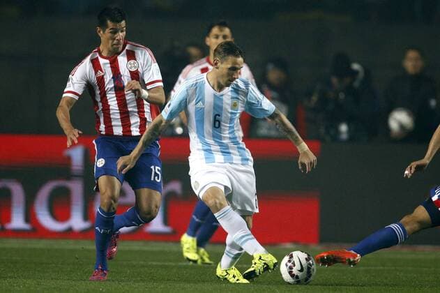 Copa America Championship 2015 . Argentina s player Lucas Biglia, center, battles for the ball against Victor Caceres of Paraguay during the 2015 Copa America football championship semifinal match at the Ester Roa stadium in Concepcion . 30 06 2015 Andres Pina Photosport Argentina v Paraguay, semifinal Copa America 2015. 