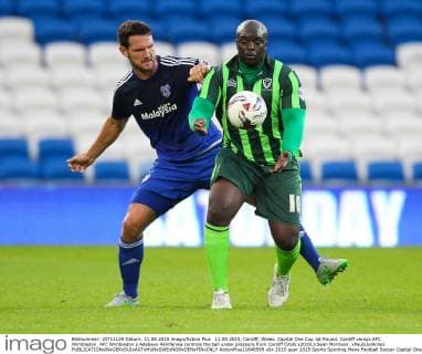 11.08.2015. Cardiff, Wales. Capital One Cup 1st Round. Cardiff versus AFC Wimbledon. AFC Wimbledon s Adebayo Akinfenwa controls the ball under pressure from Cardiff City& x2019;s Sean Morrison. xPaulxJenkinsx  ActionPlus11648599