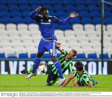 11.08.2015. Cardiff, Wales. Capital One Cup 1st Round. Cardiff versus AFC Wimbledon. Cardiff City s Kenwyne Jones challenges with AFC Wimbledon s Paul Robinson for a high ball. xPaulxJenkinsx  ActionPlus11648623