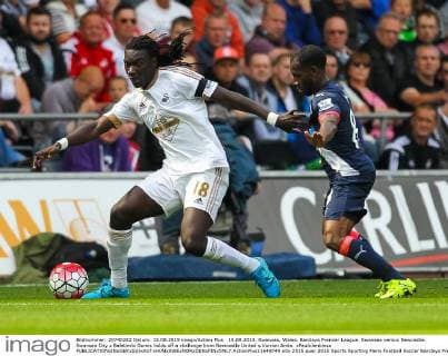 15.08.2015. Swansea, Wales. Barclays Premier League. Swansea versus Newcastle. Swansea City s Bafetimbi Gomis holds off a challenge from Newcastle United s Vurnon Anita. xPaulxJenkinsx  ActionPlus11649749