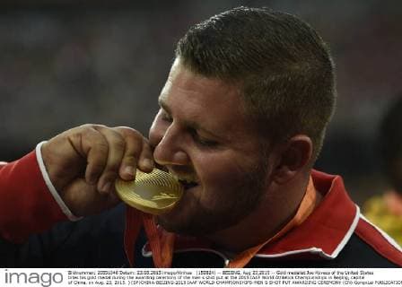 (150824) -- BEIJING, Aug 23,2015 -- Gold medalist Joe Kovacs of the United States bites his gold medal during the awarding ceremony of the men s shot put at the 2015 IAAF World Athletics Championships in Beijing, capital of China, on Aug. 23, 2015. ) (SP)CHINA-BEIJING-2015 IAAF WORLD CHAMPIONSHIPS-MEN S SHOT PUT AWARDING CEREMONY (CN) GongxLei 