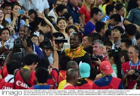 (150824) -- BEIJING, Aug. 24, 2015 -- Gold medalist Jamaica s Usain Bolt (C) films the crowd after the awarding ceremony of the men s 100m event at the 2015 IAAF Wolrd Championships at Bird s Nest National Stadium in Beijing, capital of China, Aug. 24, 2015. ) (SP)CHINA-BEIJING-2015 IAAF WORLD CHAMPIONSHIPS-MEN S 100M AWARDING CEREMONY(CN) YuexYuewei 