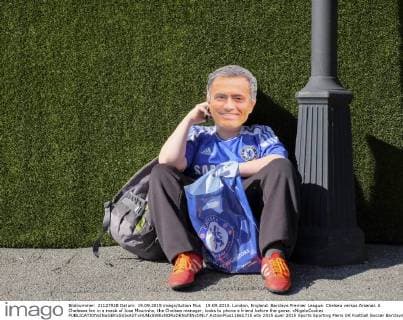 19.09.2015. London, England. Barclays Premier League. Chelsea versus Arsenal. A Chelesea fan in a mask of Jose Mourinho, the Chelsea manager, looks to phone a friend before the game. xNigelxCookex  ActionPlus11661715