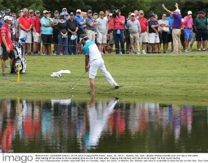 Sept. 24, 2015 - Atlanta, GA, USA - Bubba Watson stands with one leg in the water after taking off his shoe to hit his second shot on the first hole after missing the fairway with his drive to begin his first round during the Tour Championship at East Lake Golf Club on Thusday, Sept. 24, 2015, in Atlanta, Ga. Watson was able to scramble to save his par on the hole. Tour Championship - ZUMAm67_