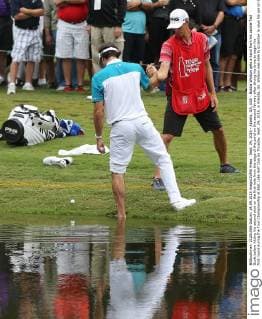 Sept. 24, 2015 - Atlanta, GA, USA - Bubba Watson gets a hand from his caddie Ted Scott before hitting his second shot on the first hole from the edge of the pond on the second fairway after slicing his drive to begin his first round during the Tour Championship at East Lake Golf Club on Thusday, Sept. 24, 2015, in Atlanta, Ga. Watson was able to scramble to save his par on the hole. Tour Championship - ZUMAm67_