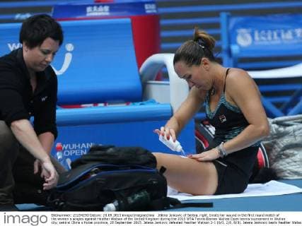 Jelena Jankovic of Serbia, right, treats her wound in the first round match of the women s singles against Heather Watson of the United Kingdom during the 2015 WTA Tennis Damen Wuhan Open tennis tournament in Wuhan city, central China s Hubei province, 28 September 2015. Jelena Jankovic defeated Heather Watson 2-1 (6 3, 2 6, 6 3). Jelena Jankovic beats Heather Watson at Wuhan Open  20150928_12415