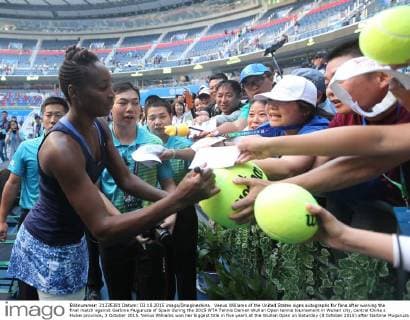 Venus Williams of the United States signs autographs for fans after winning the final match against Garbine Muguruza of Spain during the 2015 WTA Tennis Damen Wuhan Open tennis tournament in Wuhan city, central China s Hubei province, 3 October 2015. Venus Williams won her biggest title in five years at the Wuhan Open on Saturday (3 October 2015) after Garbine Muguruza quitted, making her the fifth player to pull out mid-match in the late-season tournament. Williams took the first set and was three games up in the second when the Spaniard stopped play at 53 minutes, handing the American veteran the 47th title win of her career, and her first victory at a WTA Premier Five event since she beat Victoria Azarenka in 2010 in Dubai. Wimbledon finalist Muguruza, ranked world number eight, 16 places ahead of American veteran Williams, had a tough semi-final against Germany s Angelique Kerber, winning in straight sets but falling during the closing tie break and injuring her ankle. But the 21-year-old said it was exhaustion not injury that made her pull out. Venus wins 47th career title as Muguruza quits Wuhan Open final  20151003_09366