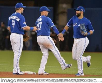 Toronto Blue Jays Jose Bautista (R) celebrates with teammates Cliff Pennington and Ryan Goins after defeating the Kansas City Royals in the ALCS game 3 at the Rogers Centre in Toronto, Canada on October 19, 2015. Toronto beat Kansas City 11-8 to narrow the Royal series lead to 2-1.  TOR2015101937 KEVINxDIETSCH