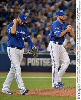 Toronto Blue Jays first baseman Chris Colabello (L) and pitcher RyanTepera walk back to their positions after the Kansas City Royals loaded the bases during the eighth inning in the ALCS game 4 at the Rogers Centre in Toronto, Canada on October 20, 2015.  TOR2015102039 KEVINxDIETSCH
