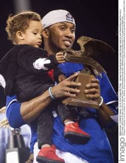 Kansas City Royals pitcher Alcides Escobar holds his son Massimiliano and the ALCS MVP trophy after the Royals won the American Leave Championship Series after defeating the Toronto Blue Jays 4-3 in game 6 at Kaufman Stadium in Kansas City on October 23, 2015. Hosmer drove home the game winning run.  KCP20151024815 KEVINxDIETSCH