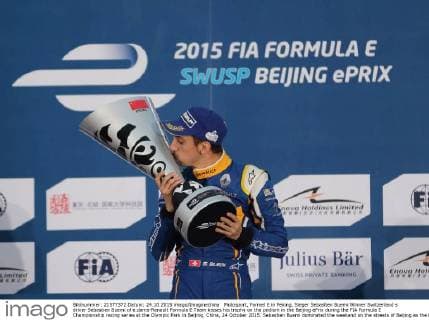Motosport, Formel E in Peking, Sieger Sebastien Buemi Winner Switzerland s driver Sebastien Buemi of e.dams-Renault Formula E Team kisses his trophy on the podium in the Beijing ePrix during the FIA Formula E Championship racing series at the Olympic Park in Beijing, China, 24 October 2015. Sebastien Buemi dominated the weekend on the streets of Beijing as the FIA Formula E series returned for its second season. The Swiss driver led the field away for 26 laps around the circuit while Mahindra s Nick Heidfeld went by Buemi s teammate Nico Prost for second at the start. Prost then overshot a corner on Lap 2 and gave up the third spot to Lucas Di Grassi. The race was slowed twice for incidents as the newly implemented Full Course Yellow came into effect where the field all had to slow down to 50 kph until the incident was cleared. The first came on Lap 3 when Simona de Silvestro crashed into a wall, with the team reporting on Twitter that she was hit from behind, while the second came at a more critical time when Antonio Felix da Costa and Jacques Villeneuve got together on Lap 14, just after most of the field had pitted. Buemi triumphs in Formula E season opener in Beijing  pbu350048_05