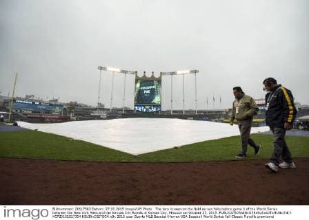 The tarp is seen on the field as rain falls before game 1 of the World Series between the New York Mets and the Kansas City Royals in Kansas City, Missouri on October 27, 2015.  KCP20151027304 KEVINxDIETSCH