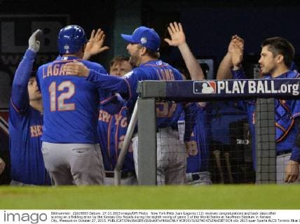 New York Mets Juan Lagares (12) receives congratulations and back slaps after scoring on a fielding error by the Kansas City Royals during the eighth inning of game 1 of the World Series at Kauffman Stadium in Kansas City, Missouri on October 27, 2015.  KCP2015102740 KEVINxDIETSCH