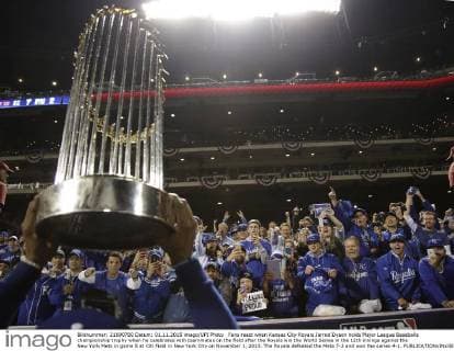 Fans react when Kansas City Royals Jarrod Dyson holds Major League Baseballs championship trophy when he celebrates with teammates on the field after the Royals win the World Series in the 12th innings against the New York Mets in game 5 at Citi Field in New York City on November 1, 2015. The Royals defeated the Mets 7-2 and won the series 4-1.  NYP20151101180 JOHNxANGELILLO