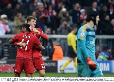 FUSSBALL CHAMPIONS LEAGUE SAISON 2014 2015 GRUPPENPHASE FC Bayern Muenchen - Arsenal London 04.11.2015 Douglas Costa und Thomas Mueller (v.l., beide FC Bayern Muenchen) bejubeln ihren Treffer. Torwart Petr Cech (Arsenal, re) wendet sich enttaeuscht ab 