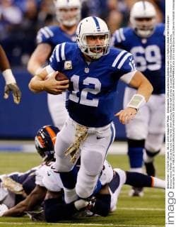 Indianapolis Colts quarterback Andrew Luck (12) fights to break free from Denver Broncos Vance Walker (96) as he runs for the first down during the first half of play at Lucas Oil Stadium in Indianapolis, Indiana, November 8, 2015.  IND20151108014 JOHNxSOMMERSxII