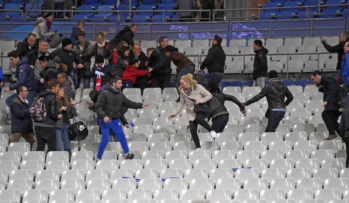 13.11.2015, Fussball Test-Länderspiel, Frankreich - Deutschland, im Stade-De-France in Paris (Frankreich), Nach dem Bombananschlag sind die Zuschauer voller Angst: Panikreaktion nach dem Spiel auf der Tribüne, die Zuschauer rennen panisch und voller Angst über die Sitze in den Innenraum auf den Platz um sich in Sicherheit zu bringen. 