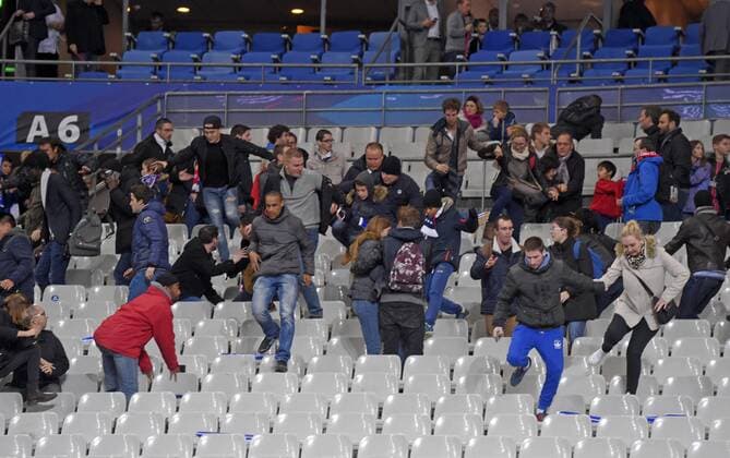 13.11.2015, Fussball Test-Länderspiel, Frankreich - Deutschland, im Stade-De-France in Paris (Frankreich), Nach dem Bombananschlag sind die Zuschauer voller Angst: Panikreaktion nach dem Spiel auf der Tribüne, die Zuschauer rennen panisch und voller Angst über die Sitze in den Innenraum auf den Platz um sich in Sicherheit zu bringen. 