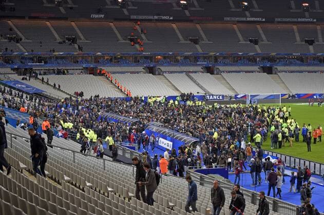 13.11.2015, Fussball Test-Länderspiel, Frankreich - Deutschland, im Stade-De-France in Paris (Frankreich), Nach bekanntwerden des Bombananschlages in der nähe des Stadions sind die Zuschauer voller Angst nach dem Spiel in den Innenraum auf den Platz gerannt um sich in Sicherheit zu bringen. Ordner begleiten sie dann zum Ausgang. 