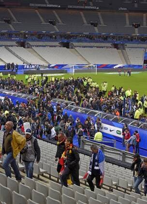 13.11.2015, Fussball Test-Länderspiel, Frankreich - Deutschland, im Stade-De-France in Paris (Frankreich), Nach bekanntwerden des Bombananschlages in der nähe des Stadions sind die Zuschauer voller Angst nach dem Spiel in den Innenraum auf den Platz gerannt um sich in Sicherheit zu bringen. Ordner begleiten sie dann zum Ausgang. 