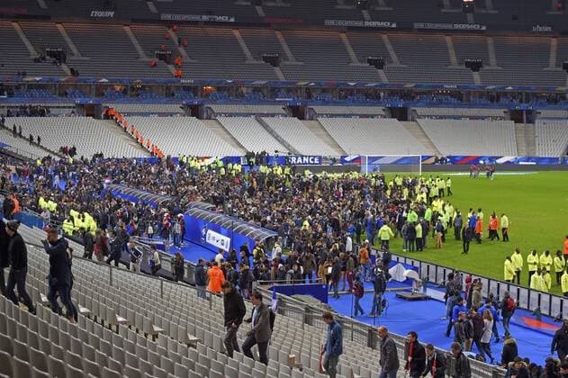 13.11.2015, Fussball Test-Länderspiel, Frankreich - Deutschland, im Stade-De-France in Paris (Frankreich), Nach bekanntwerden des Bombananschlages in der nähe des Stadions sind die Zuschauer voller Angst nach dem Spiel in den Innenraum auf den Platz gerannt um sich in Sicherheit zu bringen. Ordner begleiten sie dann zum Ausgang. 