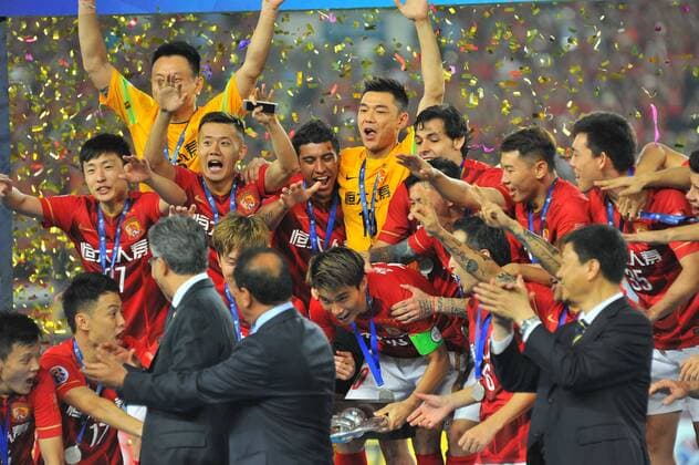 Players of China s Guangzhou Evergrande celebrate at the award ceremony after defeating UAE s Al Ahli during their second final match to win the AFC Champions League 2015 in Guangzhou city, south China s Guangdong province, 21 November 2015. Brazilian forward Elkeson scored a stunning solo effort as China s Guangzhou Evergrande edged Emiratis Al-Ahli 1-0 on Saturday (21 November 2015) to win their second Asian Champions League title in three years. Guangzhou, who won a fifth consecutive Chinese title three weeks ago, will now represent Asia at the FIFA Club World Cup in Japan next month after coach Luiz Felipe Scolari extended his unbeaten run to 23 matches since taking charge in June. Guangzhou Evergrande win second Asian Champions League title in three years  20151121_66416