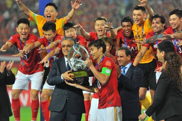 Zheng Zhi, center, of China s Guangzhou Evergrande receives the champion trophy in front of teammates at the award ceremony after they defeated UAE s Al Ahli during their second final match to win the AFC Champions League 2015 in Guangzhou city, south China s Guangdong province, 21 November 2015. Brazilian forward Elkeson scored a stunning solo effort as China s Guangzhou Evergrande edged Emiratis Al-Ahli 1-0 on Saturday (21 November 2015) to win their second Asian Champions League title in three years. Guangzhou, who won a fifth consecutive Chinese title three weeks ago, will now represent Asia at the FIFA Club World Cup in Japan next month after coach Luiz Felipe Scolari extended his unbeaten run to 23 matches since taking charge in June. Guangzhou Evergrande win second Asian Champions League title in three years  20151121_66434