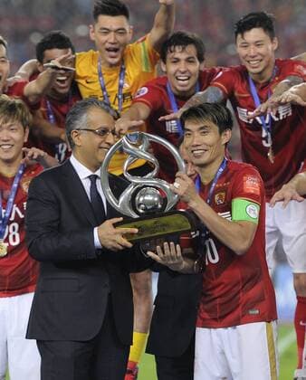 GUANGZHOU, CHINA - NOVEMBER 21: (CHINA OUT) Zheng Zhi 10 of Guangzhou Evergrande receives the trophy from AFC President Shaikh Salman bin Ebrahim Al Khalifa after winning the second leg of the AFC Champions League final match between Guangzhou Evergrande and Al Ahli at the Tianhe Sports Center on November 21, 2015 in Guangzhou, China.  CFP476177630 