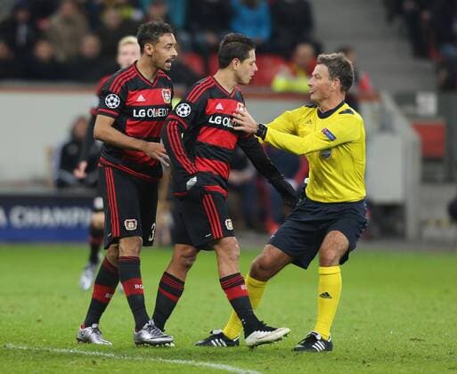 Leverkusen, Germany, 9th Dec 2015. Champions League, Bayer 04 Leverkusen vs FC Barcelona Barca Schiedsrichter Mark Clattenburg trennt Chicharito (M) und Karim Bellarabi (beide Leverkusen).