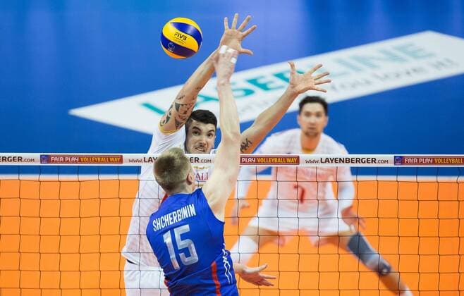Berlin, Deutschland, 06.01.2016: Volleyball Olympia Qualifikation Männer Maenner 2016 - Spiel 6 Russland - Frankreich. Dmitry Shcherbinin (Russia 15) gegen den Block aus Nicolas Le Goff (France 14)