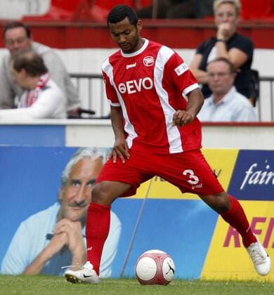 Fussball, 2. Bundesliga, Kickers Offenbach vs. FC Augsburg Fussball, 2. Bundesliga, Kickers Offenbach vs. FC Augsburg, Santos de Brito Sidney (O) wird von Rudi Völler auf der Bandenwerbung beobachtet.