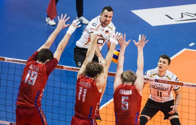 Berlin, Deutschland, 09.01.2016: Volleyball Olympia Qualifikation Männer Maenner 2016 - Spiel Deutschland - Russland. Georg Grozer (Germany 9) gegen den Block aus v.li. Egor Kliuka (Russia 19), Andrey Ashchev (Russia 11) und Sergey Grankin (Russia 5)