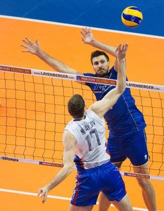Berlin, Deutschland, 10.01.2016: Volleyball Olympia Qualifikation Männer Maenner 2016 - Finale Russland - Frankreich Russland - Frankreich. Maxim Mikhailov (Russia 17) gegen den Block aus Antonin Rouzier (France 4)