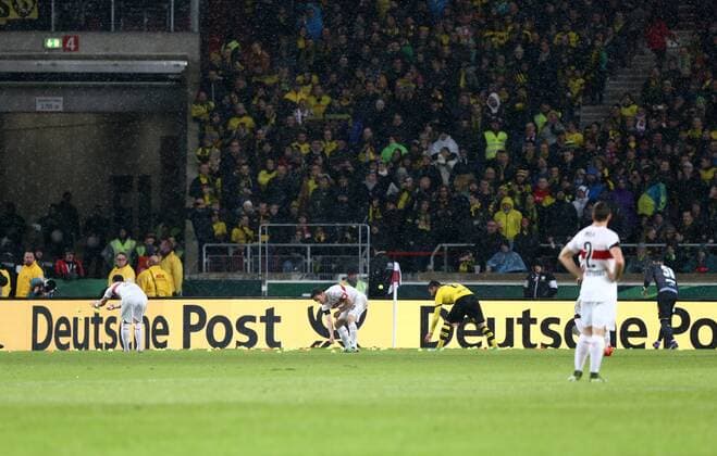 Dienstag 09.02.2016, Saison 2015 2016, DFB-Pokal, Viertelfinale in der Stuttgarter Mercedes-Benz Arena, VfB Stuttgart - BVB Borussia Dortmund, Die BVB-Fans protestieren gegen die hohen Eintrittspreise zum Pokalspiel im Rahmen der Aktion Kein Zwanni Fußball muss bezahlbar sein. Spruchband: Eure Preise - Großes Tennis und die Fans werfen gelbe Tennisbälle auf das Spielfeld und erzwingen eine Spielunterbrechung Die Stuttgarter und Dortmunder Spieler werfen die Tennisbälle vom Spielfeld