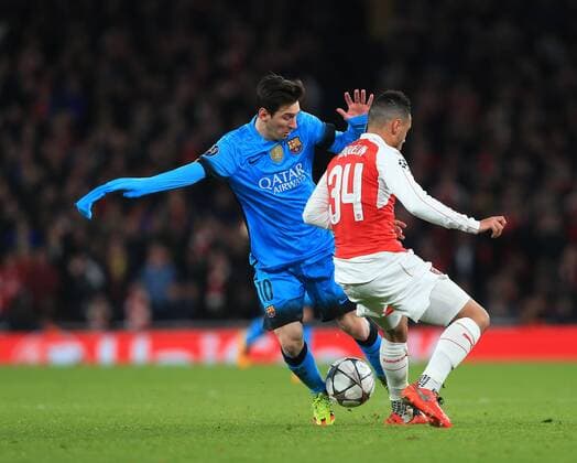 Fußball, Champions League, FC Arsenal - FC Barcelona Arsenal s Francis Coquelin pulls on Barcelona s Lionel Messi s shirt UEFA Champions League 2nd Round First Leg - Arsenal vs Barcelona - Emirates Stadium -England - 23rd February 2016 - Picture David Klein Sportimage EDITORIAL USE ONLY. No use with unauthorised audio, video, data, fixture lists, club league logos or live services. Online in-match use limited to 120 images, no video emulation. No use in betting, games or single club league player publications.