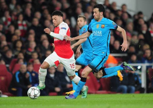 Football - 2015 2016 Champions League - Round of 16, First Leg: Arsenal vs. Barcelona Alex Oxlade Chamberlain of Arsenal and Sergio Busquets of Barcelona at The Emirates. COLORSPORT ANDREW COWIE 