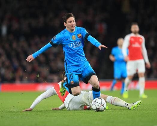 Barcelona s Lionel Messi goes past Arsenal s Aaron Ramsey s tackle UEFA Champions League 2nd Round First Leg - Arsenal vs Barcelona - Emirates Stadium -England - 23rd February 2016 - Picture David Klein Sportimage EDITORIAL USE ONLY. No use with unauthorised audio, video, data, fixture lists, club league logos or live services. Online in-match use limited to 120 images, no video emulation. No use in betting, games or single club league player publications.