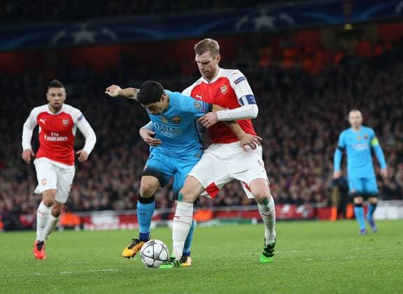 Arsenal s Per Mertesacker tussles with Barcelona s Luis Suarez UEFA Champions League 2nd Round First Leg - Arsenal vs Barcelona - Emirates Stadium -England - 23rd February 2016 - Picture David Klein Sportimage EDITORIAL USE ONLY. No use with unauthorised audio, video, data, fixture lists, club league logos or live services. Online in-match use limited to 120 images, no video emulation. No use in betting, games or single club league player publications.