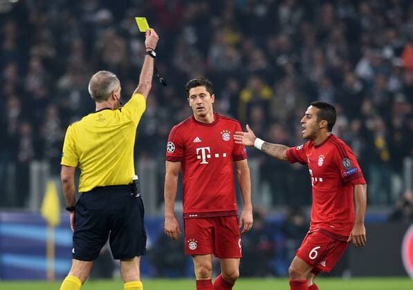 FUSSBALL CHAMPIONS LEAGUE SAISON 2015 2016 ACHTELFINALE HINSPIEL Juventus Turin - FC Bayern Muenchen 23.02.2016 Schiedsrichter Martin Atkinson (kli) zeigt Robert Lewandowski (Mitte) die Gelbe Karte. Thiago Alcantara (re, FC Bayern Muenchen) reklamiert 