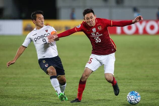 GUANGZHOU, CHINA - FEBRUARY 24: (CHINA OUT) Li Xuepeng 35 of Guangzhou Evergrande and Hwang Ji-soo 9 of Pohang Steelers compete for the ball during the AFC Champions League Group H match between Guangzhou Evergrande and Pohang Steelers at Tianhe Center on February 24, 2016 in Guangzhou, China.  CFP480110905 