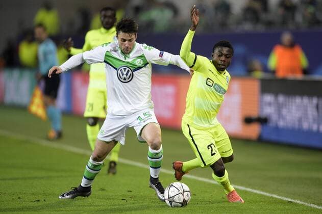 Wolfsburg s Christian Trasch and Gent s Moses Simon fight for the ball during a soccer game between German team VfL Wolfsburg and Belgian club KAA Gent, the return game of the 1 8 final s of the UEFA Champions League competition, Tuesday 08 March 2016 in Wolfsburg, Germany. Wolfsburg won the first leg 2-3. YORICKxJANSENS  x04807144x