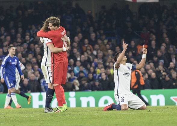 Football - 2015 2016 Champions League - Round of 16, Second Leg: Chelsea 1 vs. Paris Saint-Germain 2 Kevin Trapp of PSG hugs team mate David Liiz as Thiago Silva sinks to his knees as PSG take the lead at Stamford Bridge. COLORSPORT DANIEL BEARHAM  che_psg