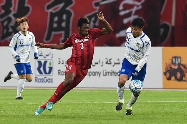 SHANGHAI, CHINA - MARCH 15: (CHINA OUT) Asamoah Gyan 3 of Shanghai SIPG and Yasuyuki Konno 15 of Gamba Osaka compete for the ball during the AFC Champions League Group G match between Shanghai SIPG and Gamba Osaka at Shanghai Stadium on March 15, 2016 in Shanghai, China.  CFP481171275 