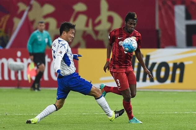 SHANGHAI, CHINA - MARCH 15: (CHINA OUT) Asamoah Gyan 3 of Shanghai SIPG and Yasuyuki Konno 15 of Gamba Osaka compete for the ball during the AFC Champions League Group G match between Shanghai SIPG and Gamba Osaka at Shanghai Stadium on March 15, 2016 in Shanghai, China.  CFP481171278 