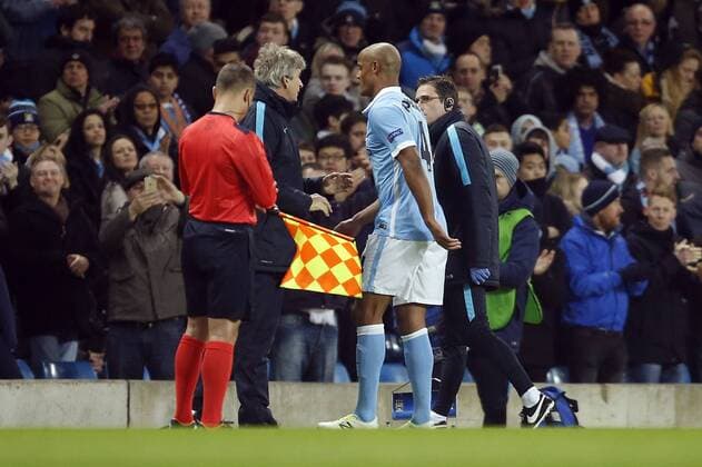 Manuel Pellegrini, manager of Manchester City speaks to Vincent Kompany as he heads off injured during the UEFA Champions League match at the Etihad Stadium. Photo credit should read: Philip Oldham Sportimage EDITORIAL USE ONLY. No use with unauthorised audio, video, data, fixture lists, club league logos or live services. Online in-match use limited to 120 images, no video emulation. No use in betting, games or single club league player publications.